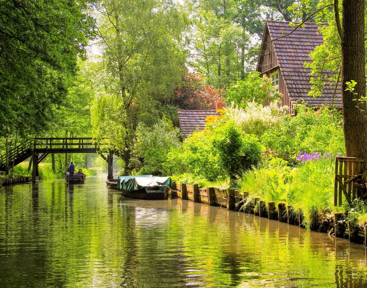 Fließ im Spreewald mit Holzbrücke und Kahn