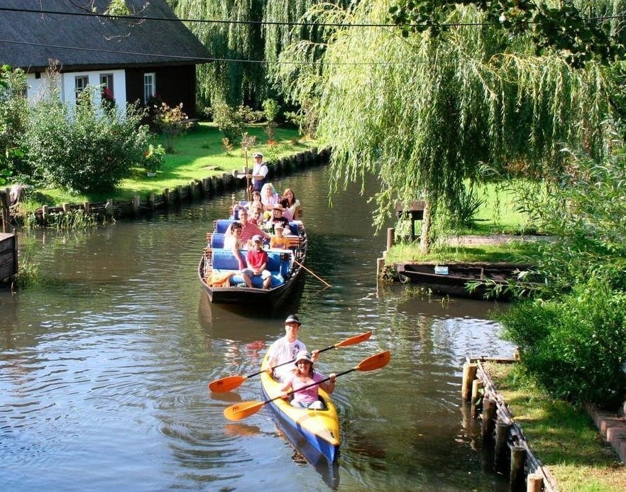 Kahn und Kajaks auf einem Fließ im Spreewald