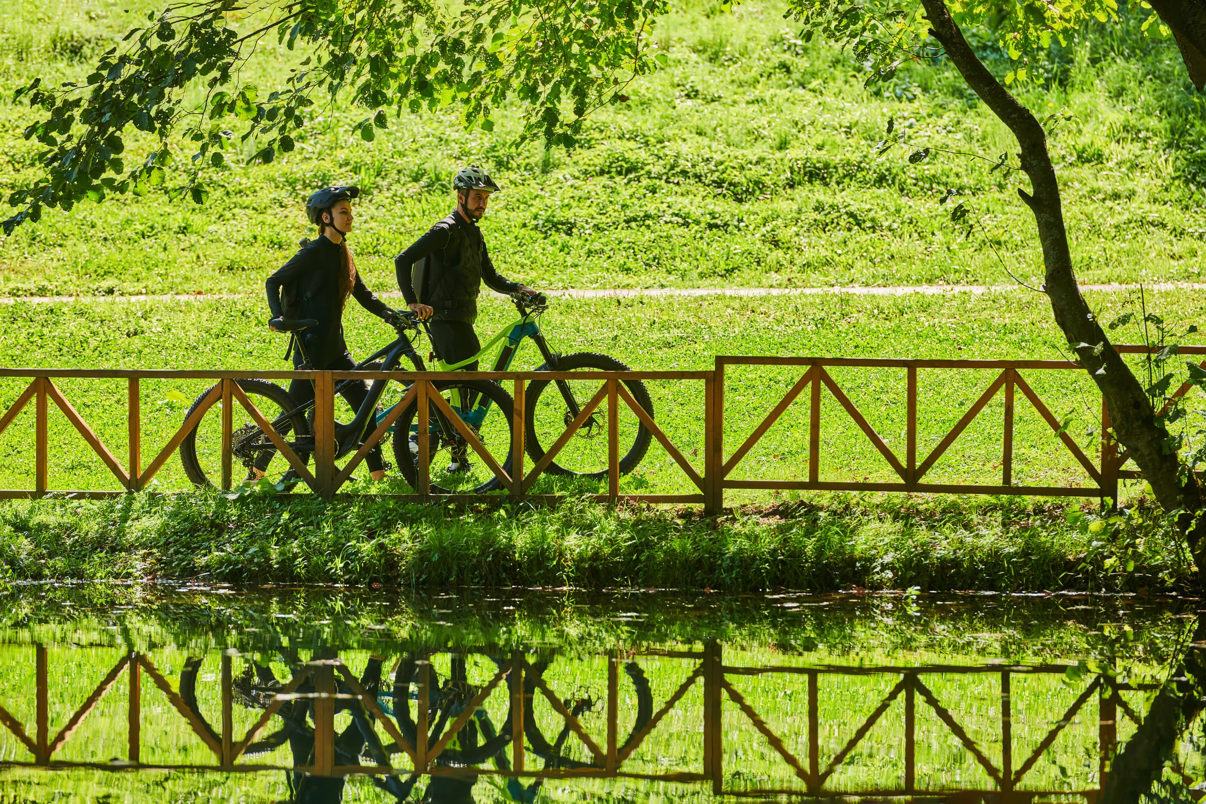Zwei Radfahrer auf einer Holzbrücke im grünen Oberspreewald