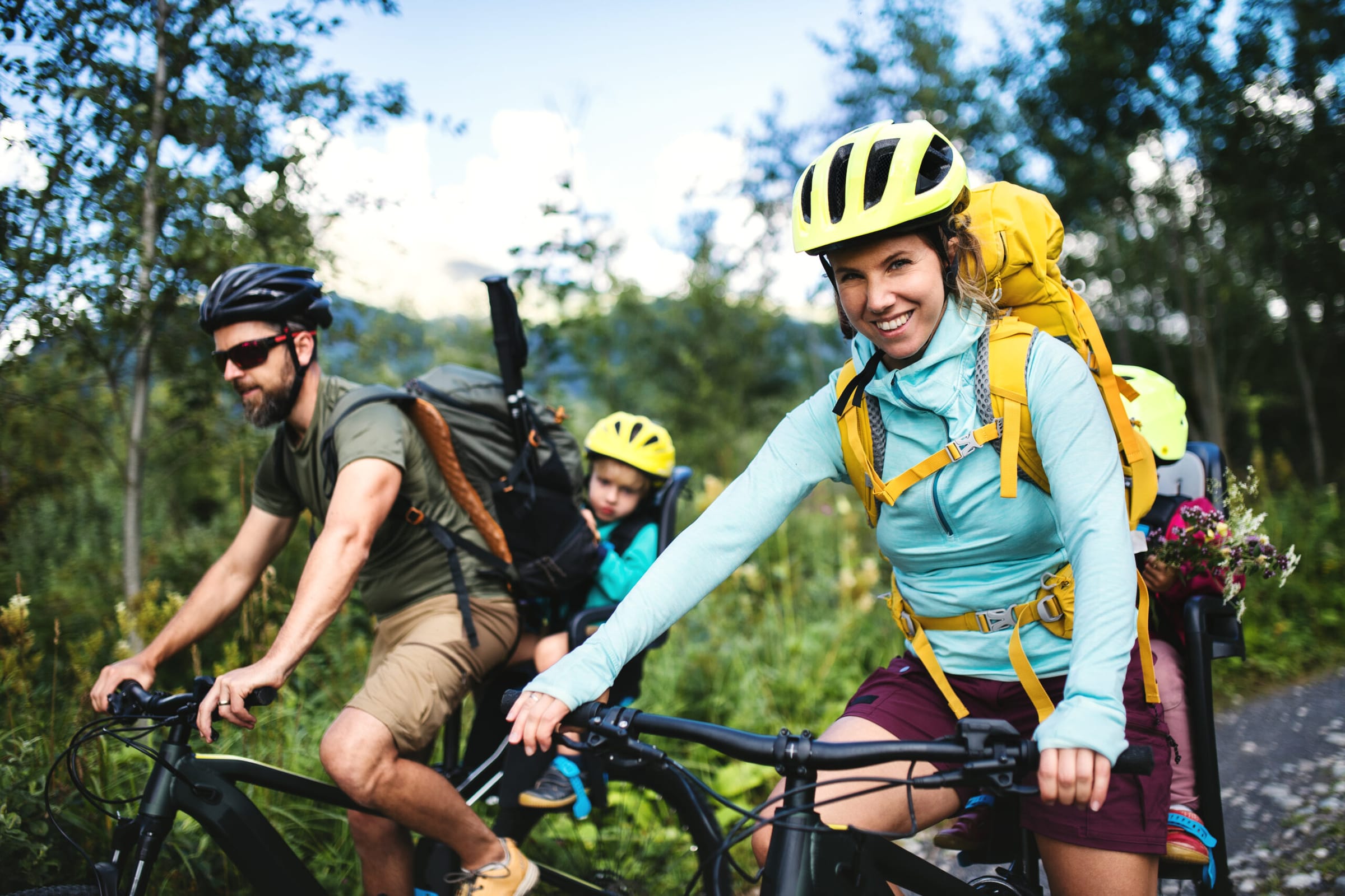 Radfahrer mit Helm und Kinderanhänger auf einer sportlichen Waldtour